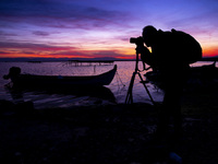 Photographer In Action During A Sunset