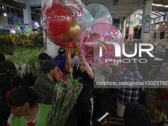 A woman holds several balloons inside the Jamaica Market in Mexico City where dozens of people came to buy flowers and gifts for Mother's Da...