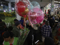 A woman holds several balloons inside the Jamaica Market in Mexico City where dozens of people came to buy flowers and gifts for Mother's Da...