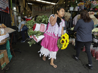 A woman holds a bouquet of flowers inside the Jamaica Market in Mexico City where dozens of people came to buy flowers and gifts for Mother'...