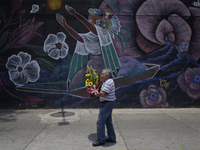 A man holds a bouquet of flowers outside the Jamaica Market in Mexico City where dozens of people came to buy flowers and gifts for Mother's...