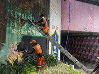 Municipal worker removed a mural promoting awareness of the coronavirus disease (Covid-19) and replaced it with another image in Jakarta, In...