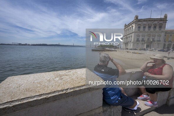Several people are seen resting near the Tejo river bank, in the neighborhood of Baixa, Lisbon. 02 May 2023. 