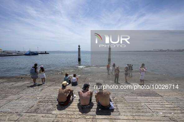 Several people are seen resting on the banks of the Tejo river, in the neighborhood of Baixa, Lisbon. 02 May 2023. 