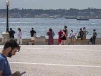 Several people are seen resting on the banks of the Tejo river, in the neighborhood of Baixa, Lisbon. 02 May 2023. (