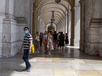 A person wearing a protective mask is seen walking near the Augusta arch, in the Baixa district, Lisbon. May 02, 2023. (
