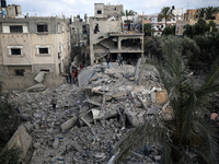 Palestinians gather at the site of an Israeli airstrike amid Israel-Gaza fighting in Deir al-Balah town in the central Gaza Strip, May 13, 2...
