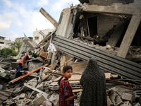 People salvage belongings amidst the rubble of a building hit by an Israeli air strike, in Gaza city on May 13, 2023. Israel and Gaza traded...