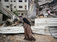 People salvage belongings amidst the rubble of a building hit by an Israeli air strike, in Gaza city on May 13, 2023. Israel and Gaza traded...