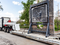 A cut-out of the wall with Banksy artwork is placed on a semi-trailer track  to be moved for preservation in Irpin, Kyiv region, Ukraine on...