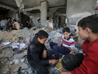 Palestinians eat amidst the rubble of their house in Gaza City, on May 14, 2023, following a ceasefire ending five days of deadly fighting b...