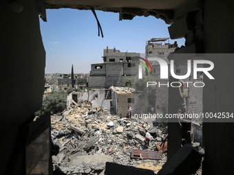 Palestinians inspect their belongings amidst the rubble of their house in Gaza City, on May 14, 2023, following a ceasefire ending five days...