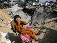 A Palestinian boy sits amidst the rubble of his house in Gaza City, on May 15, 2023, following a ceasefire ending five days of deadly fighti...
