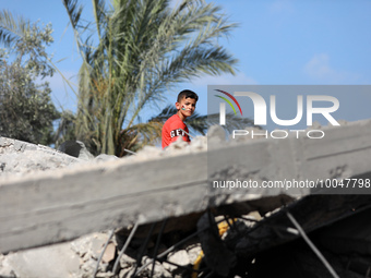 A Palestinian boy sits amidst the rubble of a destroyed building in Deir al-Balah in central Gaza Strip on May 15, 2023 following a ceasefir...