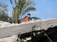 A Palestinian boy sits amidst the rubble of a destroyed building in Deir al-Balah in central Gaza Strip on May 15, 2023 following a ceasefir...