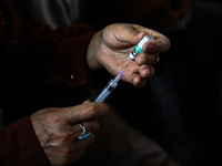 A health worker fills a Syringe with Vaccine during a Vaccination drive ahead of Hajj pilgrimage at SDH Sopore District Baramulla Jammu and...