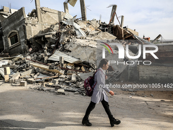 A Palestinian student walks past amidst the rubble of his house in Beit Lahia in the northern Gaza Strip, on May 16, 2023, following a cease...