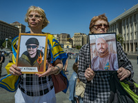 Two women holds the photos of their relatives, soldiers in captivity of the russian army for more than one year. They were part of a march i...