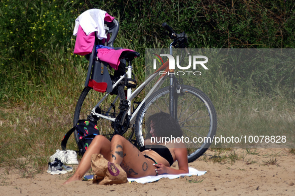 ODESA, UKRAINE - MAY 21, 2023 - A woman sunbathes on the ''Dog Beach'', Odesa, southern Ukraine. NO USE RUSSIA. NO USE BELARUS.