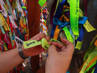Faithful place the ribbons with thanks for Mary Undoer of Knots in the sanctuary located in the jungle of Cancun, the only church of its kin...