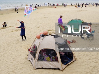 Tourists camp in tents on the beach in Yantai, Shandong province, China, May 7, 2023. According to the 2022-2023 China Camping Industry Rese...