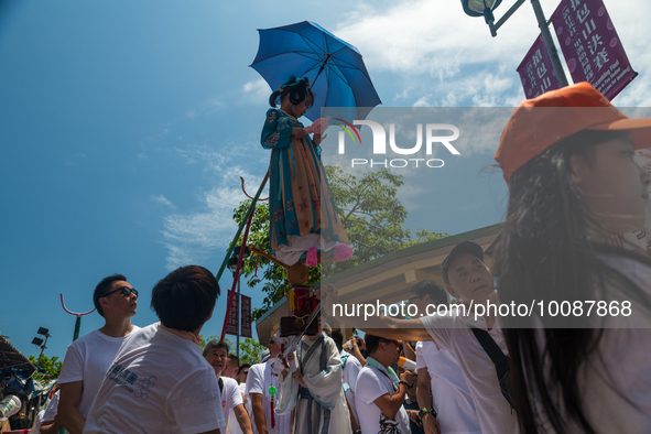 

A child in traditional dress is being hoisted and carried around under the scorching sun during a traditional procession in Cheung Chau, H...
