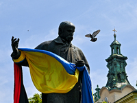 LVIV, UKRAINE - MAY 28, 2023 - A pigeon flies past the monument to Ukrainian poet and artist Taras Shevchenko decorated with a Ukrainian fla...