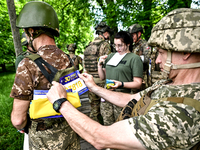 ZAPORIZHZHIA REGION, UKRAINE - MAY 28, 2023 - A serviceman of the 128th Mountain Assault Brigade attaches a sticker with a number to a bulle...