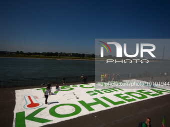 

General views of several climate activists painting a huge message of ''1.5 Degree Goal Instead of Coal Deal'' in front of the Rhine River...