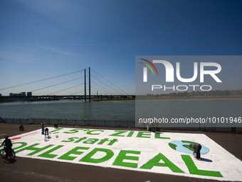 

General views of several climate activists painting a huge message of ''1.5 Degree Goal Instead of Coal Deal'' in front of the Rhine River...