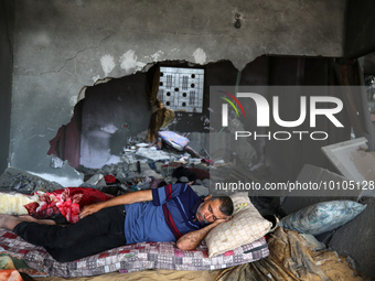 

A Palestinian man is sleeping in his house, which was destroyed by Israeli air strikes during recent Israel-Gaza fighting, in Beit Lahiya,...