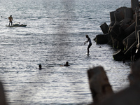 A Palestinian youth jumps into the Mediterranean Sea at the seaport in Gaza City on May 31, 2023.  (