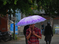  A boy walks as it rains in Srinagar,Kashmir on June 01, 2023. Rains continued across Jammu and Kashmir leading to the drop in temperature,...