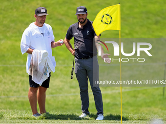 Mark Hubbard of Denver, Colorado talks with his caddie on the 18th green during the first round of the The Memorial Tournament presented by...