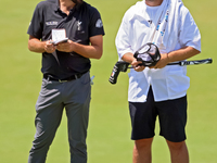 Mark Hubbard of Denver, Colorado talks with his caddie on the 18th green during the first round of the The Memorial Tournament presented by...