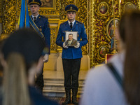 A scort soldier holds the photo of Mikola Vasiliovich during a holy mass in Saint Michael's Golden Domed Cathedral. Mikola was a ukrainian s...