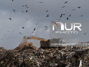 A man as an excavator searches in a garbage dumpyard ground on the outskirts of Mumbai, India, 02 May, 2023.  (