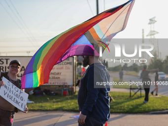 A pro-LGBTQ protestor holds a gay/transgender pride flag outside First Christian Church in Katy, Texas on June 3, 2023. (