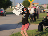 A pro-LGBTQ protestor holds a sign that reads, ''trans lives matter!'' Outside First Christian Church in Katy, Texas on June 3, 2023. (