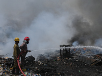 Firefighters spray water as they extinguish fire that was broke out in the slum cluster of Jahangirpuri area in New Delhi, India on June 4,...