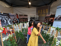 Two girls visit the gallery booth featuring photos of the June 4th crackdown, during the commemoration of the 34th anniversary  Tiananmen Ma...