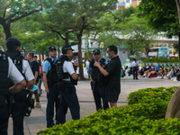 

Hong Kong, China, on June 4, 2023, a man dressed in black is being stopped and searched by the police in Victoria Park. He will be arreste...