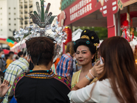 

A woman wearing an elaborate headdress is smiling at a pro-China fair being held in Victoria Park, Hong Kong, China, on June 4, 2023. (