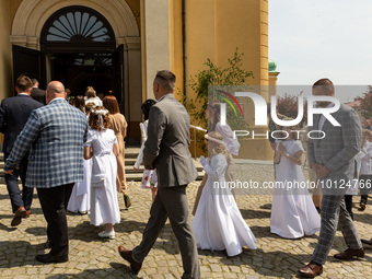 Children dressed in white dress and their parents walk into the St Mary Magdalene Church in Tychy, Poland to take First Communion on May 28,...