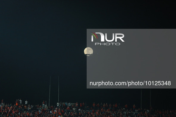 
The waning gibbous moon rises behind spectators at Cairo International Stadium in Egypt on June 4, 2023, as they watch the first-leg final...