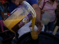  person hands out pulque (traditional Mexican alcoholic beverage) outside the Sanctuary of the Lord of Calvary located in Culhuacan, Mexico...