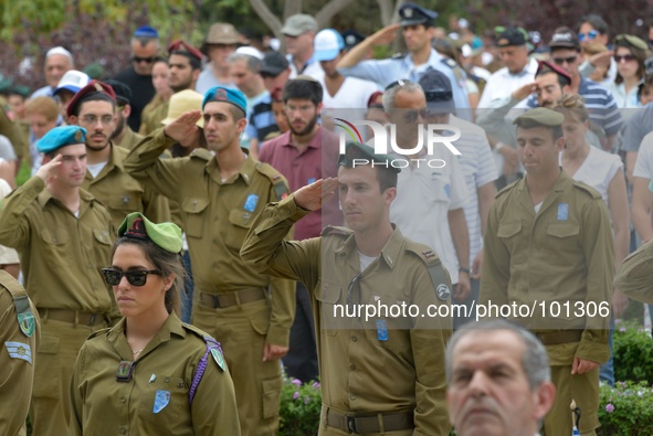 TEL AVIV, ISRAEL - MAY 05: Israeli soldiers and visitors salute and stand still during a two minutes siren at the Memorial Day ceremony at t...