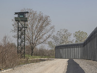 The fortification fence with a watch tower post in the background for border police and the military equipped with camera and surveillance g...
