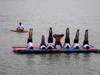 Participants perform yoga on the surface Yamuna River to mark the International Yoga Day celebrations on June 21, 2023 in New Delhi, India....
