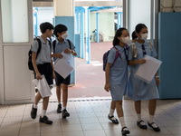 Students holding their secondary school allocation result arriving at a school hall on July 11, 2023 in Hong Kong, China. Primary School Stu...